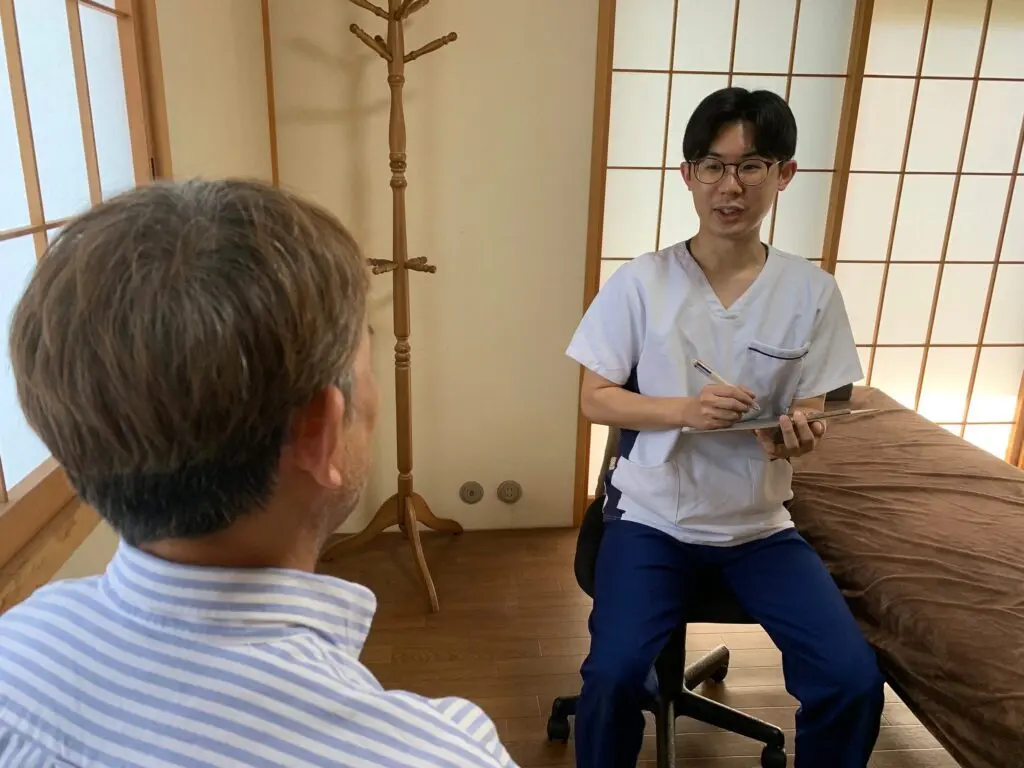 施術前に爪の状態や施術内容を説明する二宮佑太